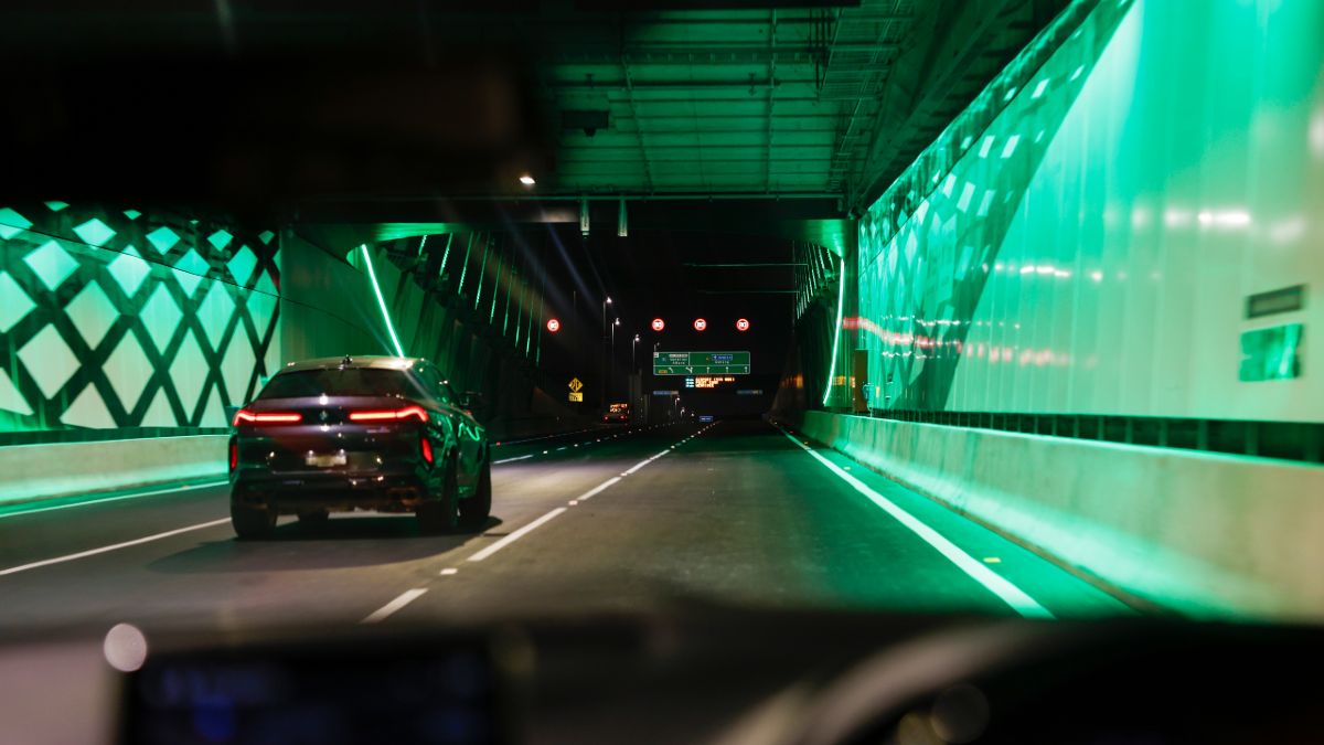 A car driving out of the West Gate Tunnel at night, from the perspective of a car dashboard