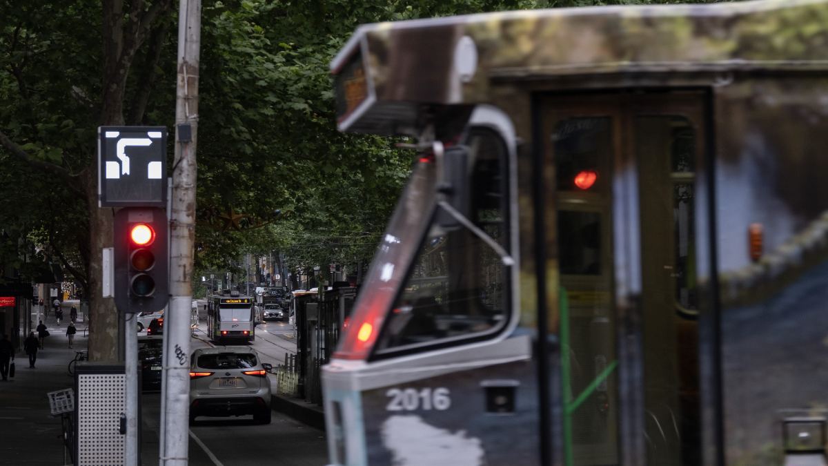 tram going through intersection; in the background is a hook turn sign