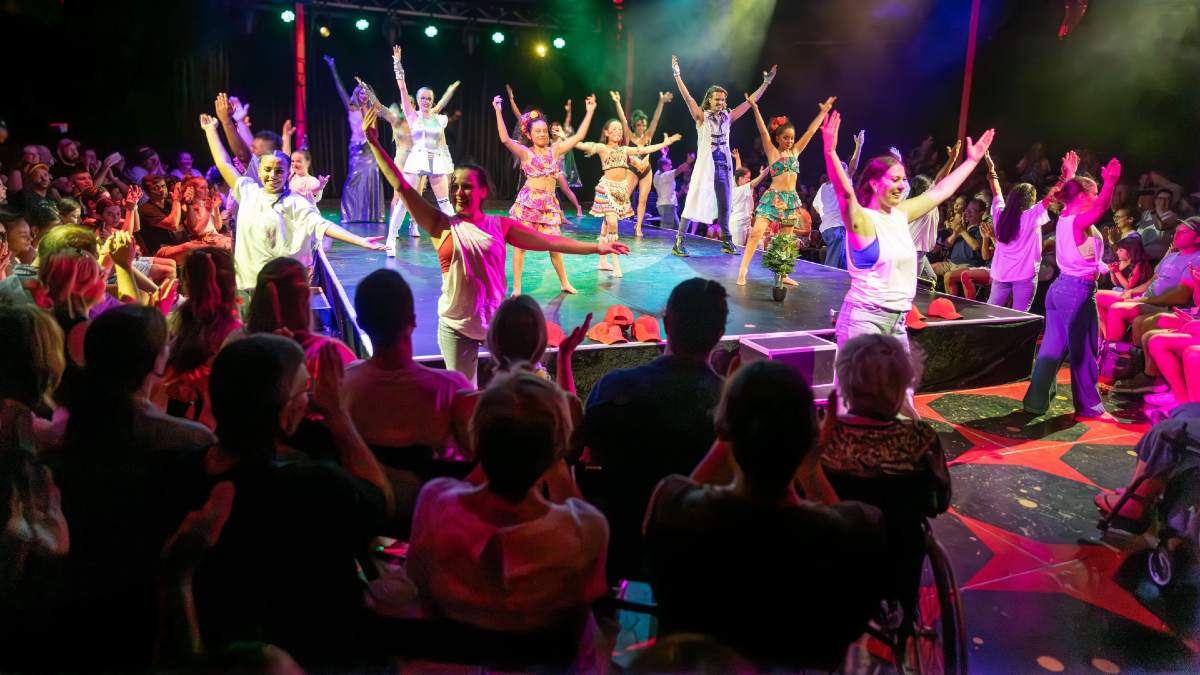 stage of performers in front of a crowd