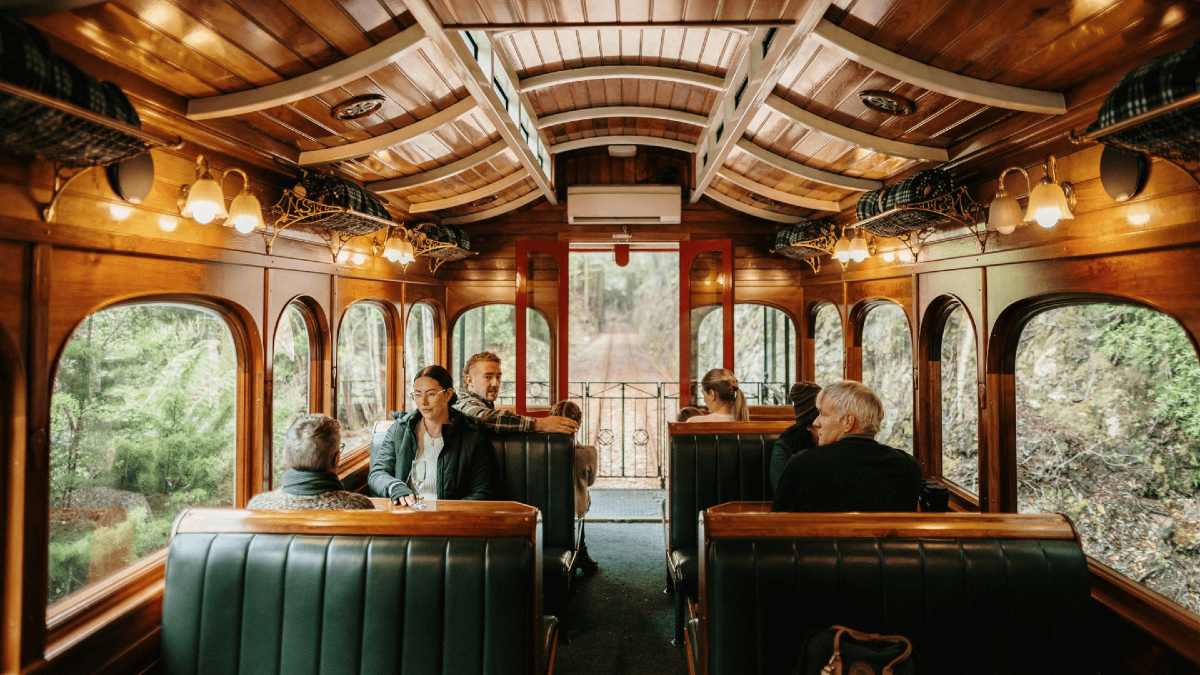 people in a rustic timber train carriage