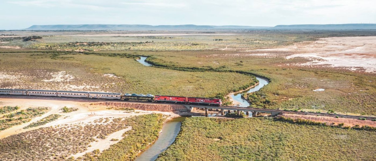 The Ghan, Flinders Ranges_Journey Beyond red train crossing river in Flinders Ranges area