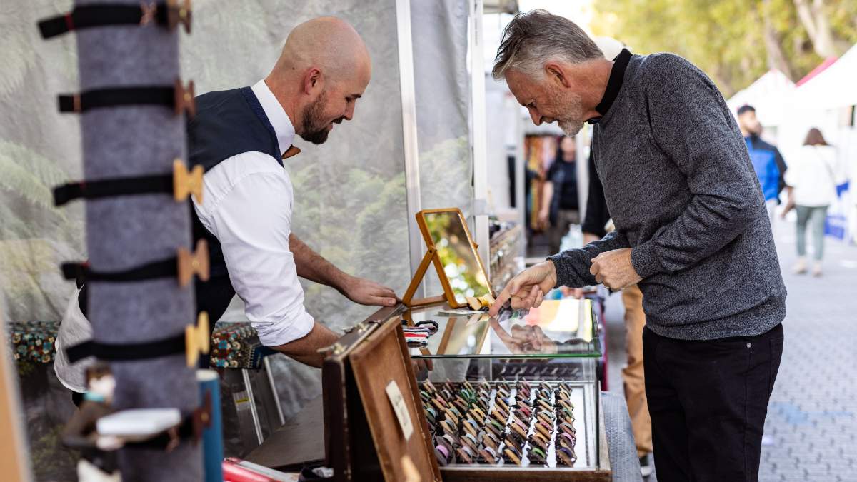 two men at a market stall examining the wares
