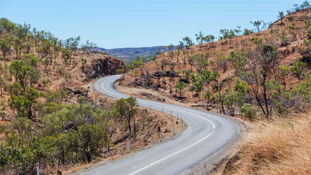 desolate road winding between dry hills