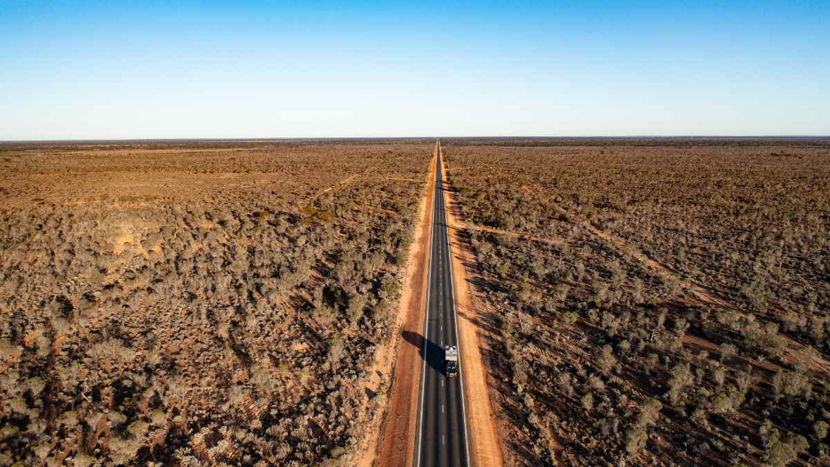 long straight desert road with one car