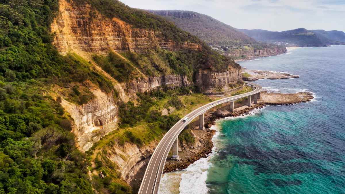 coastal road with sea cliffs on one side and clear ocean on the other