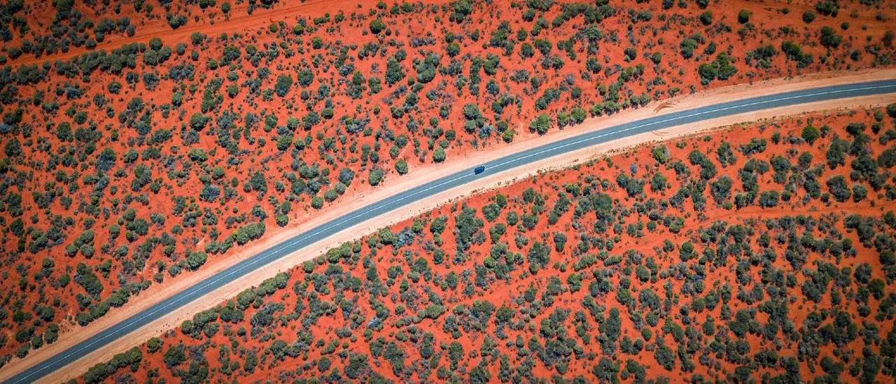 car driving on desolate road in outback