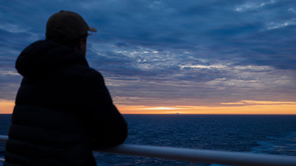Shadow of man watching sunset aboard Spirit of Tasmania.
