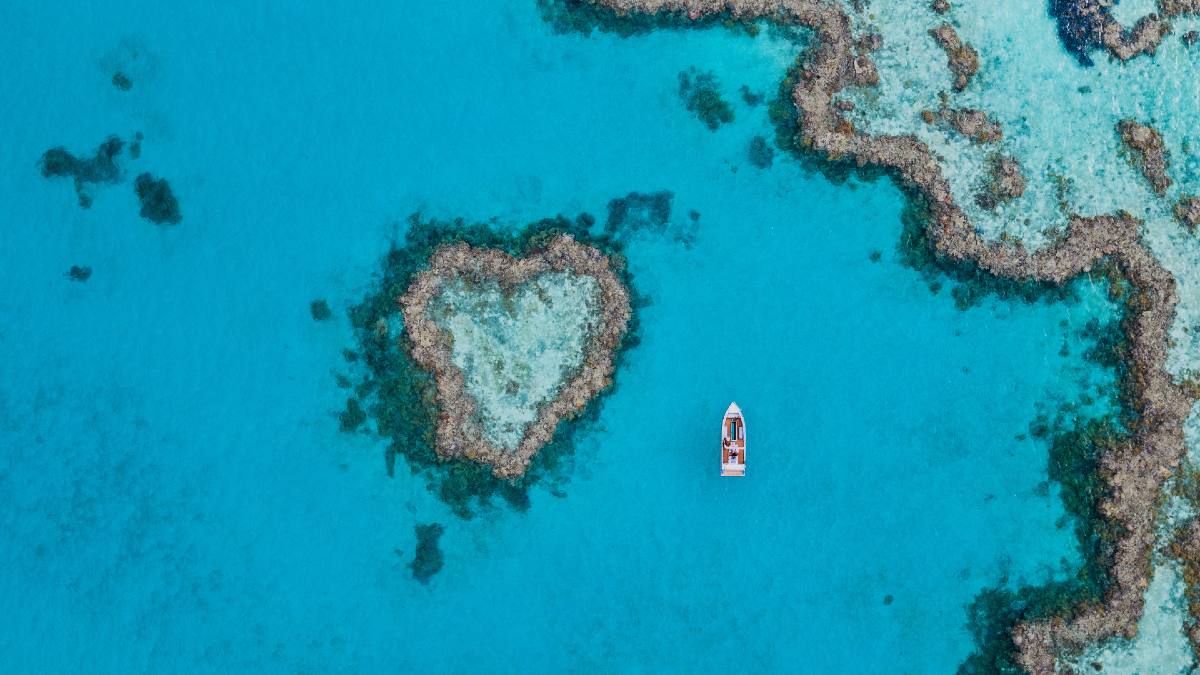 heart-shaped reef island with boat nearby