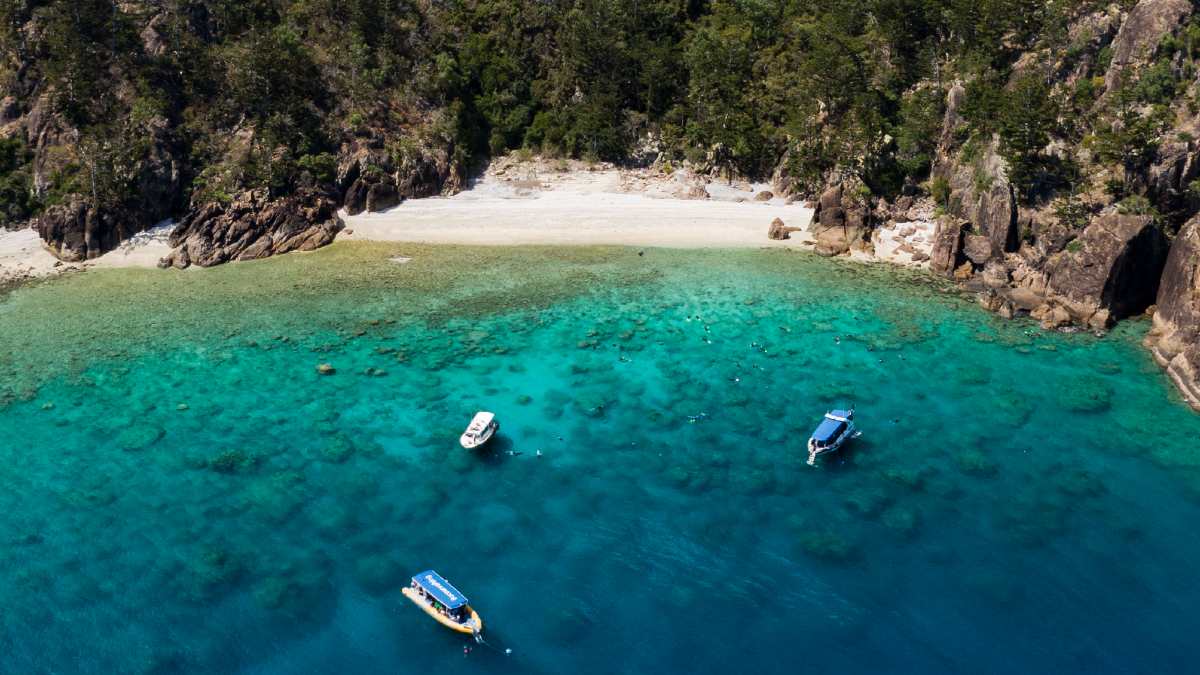 three boats anchored on a beautiful tropical reef
