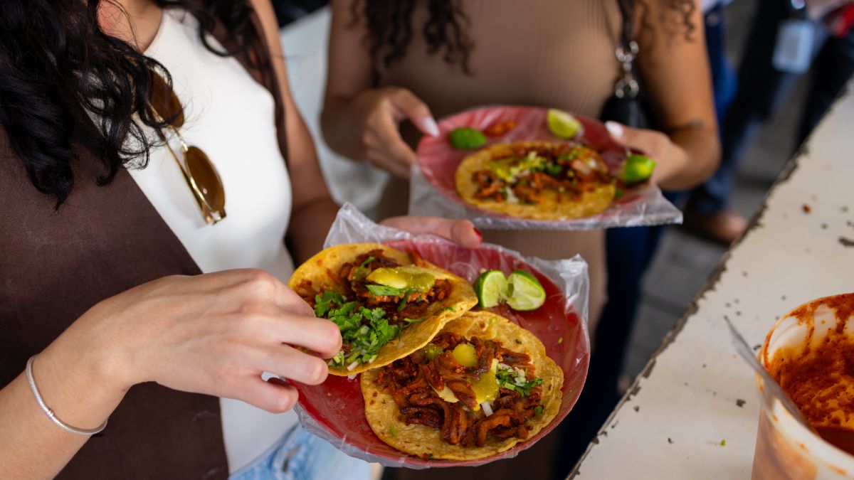 two women eating tacos al pastor