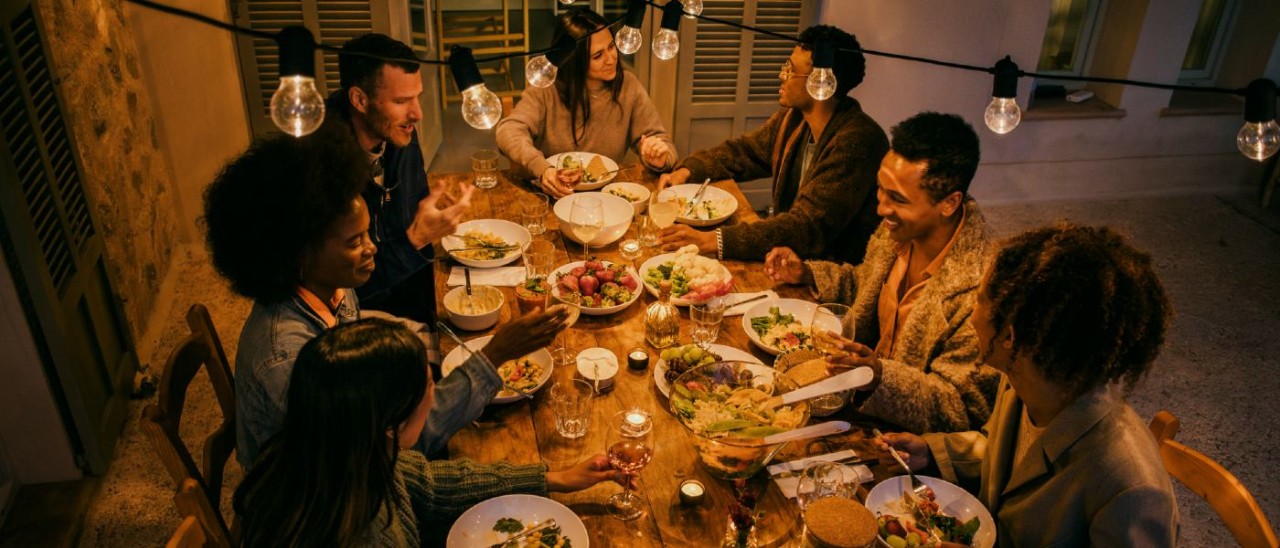 seven people enjoying a candlelit meal