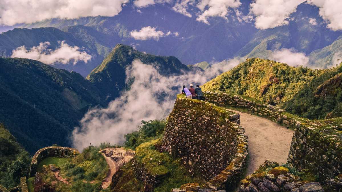 three young men at a lookout at Phuyupatamarca