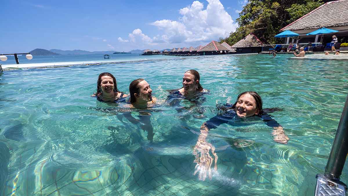 Four people in resort swimming pool in Malaysia.