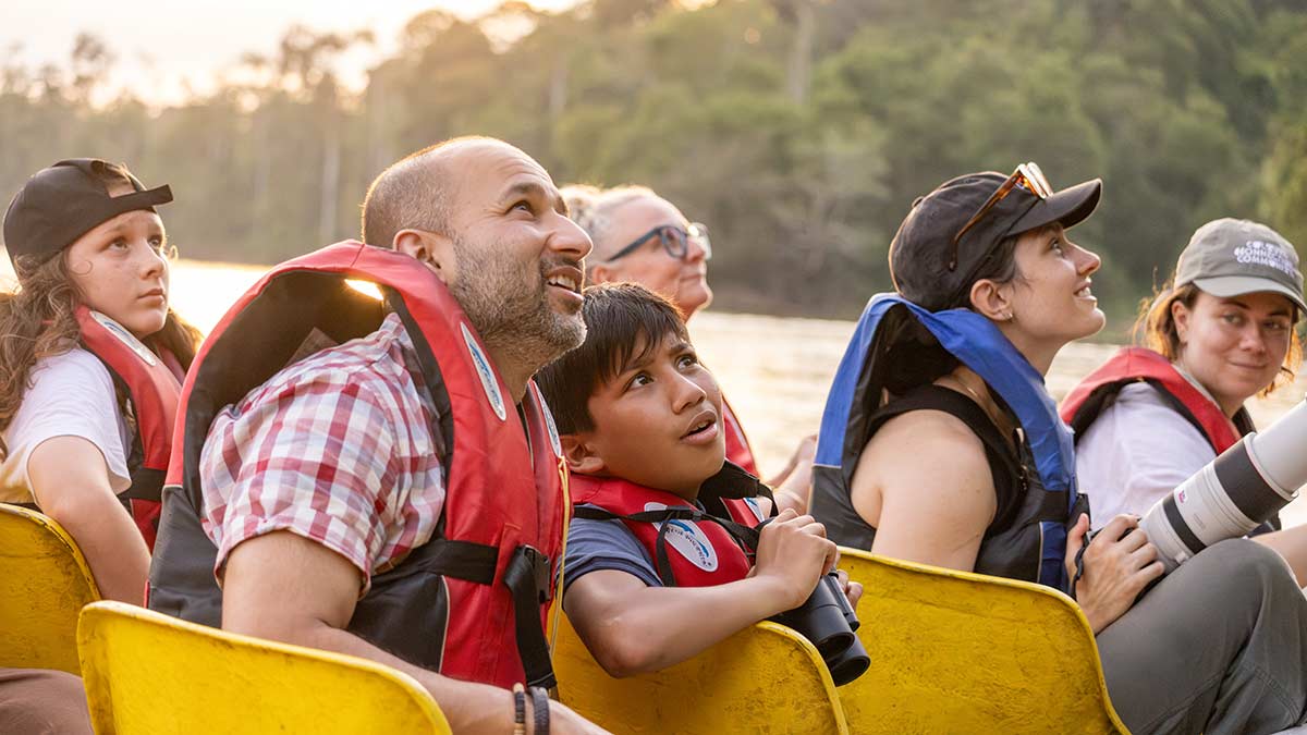 Six people on a river cruise in Malaysia with father and son in foreground.