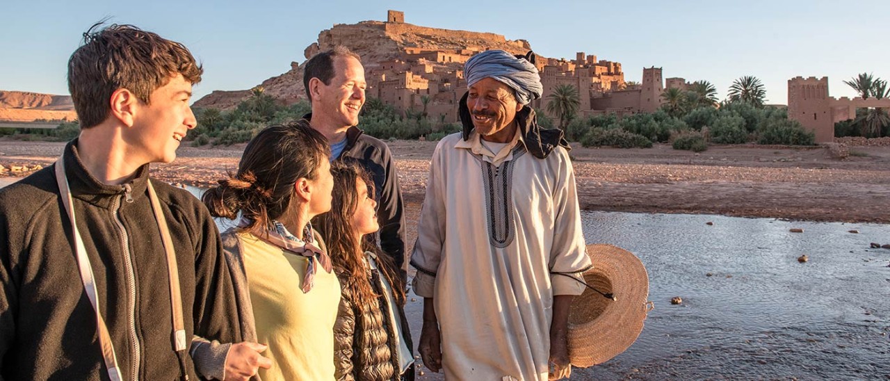 Family of four talking to local person in Morocco.