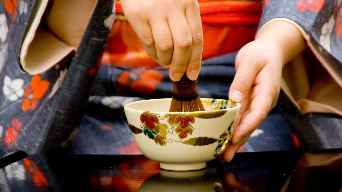 woman traditionally preparing tea for a Japanese tea ceremony