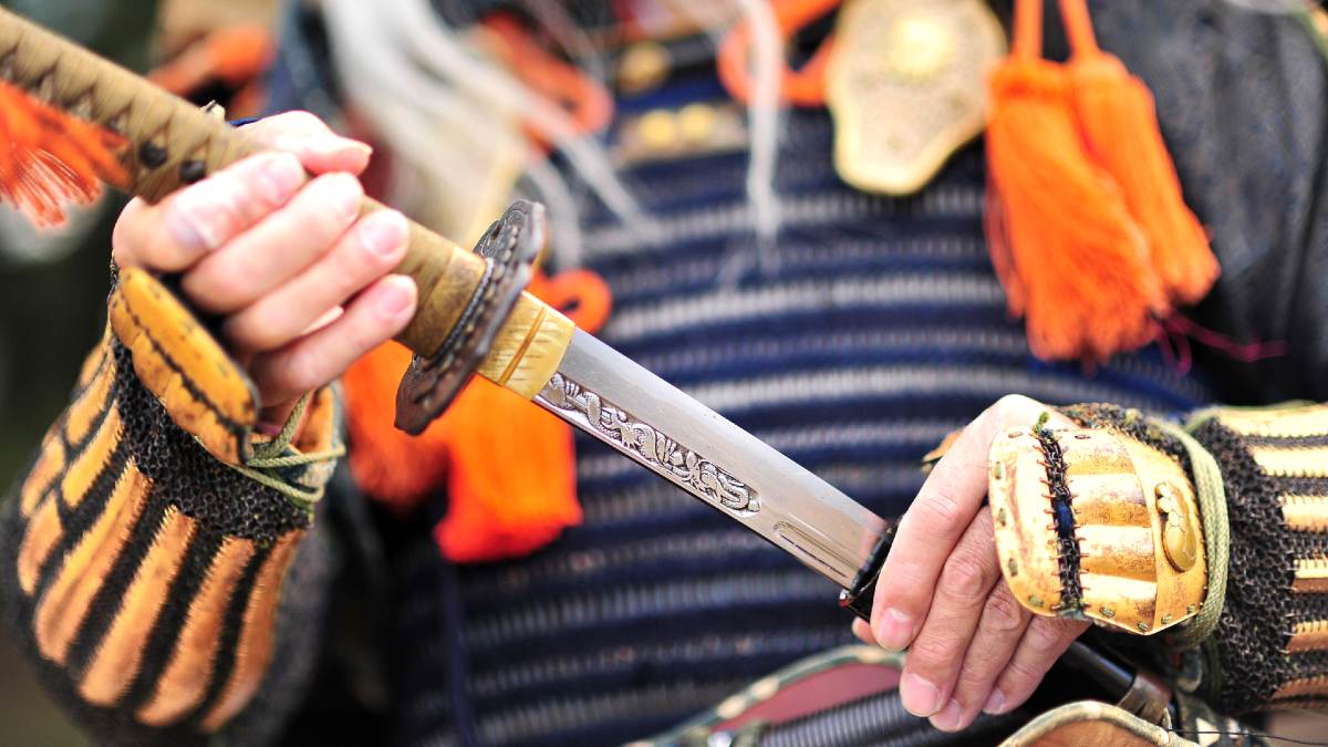 man dressed in traditional samurai armour holding a sword