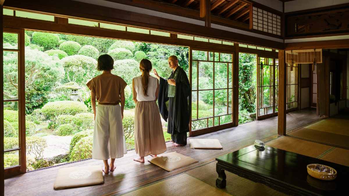 two young woman listen to a monk in a ryokan