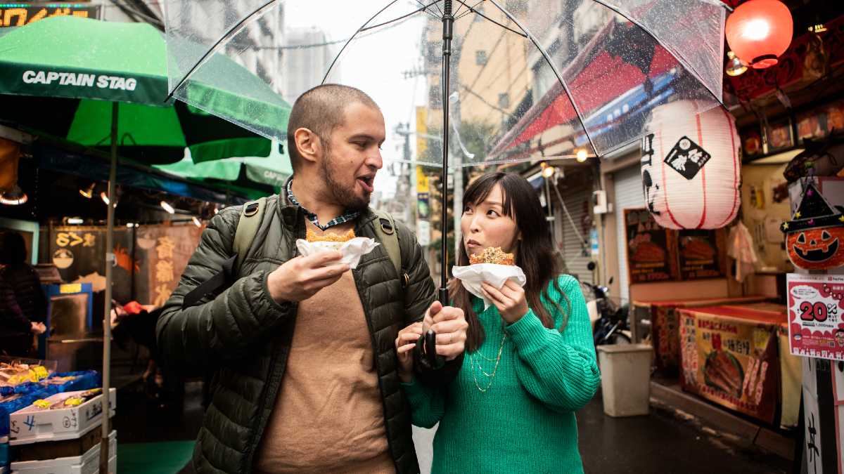 man and woman eating street food in Japan