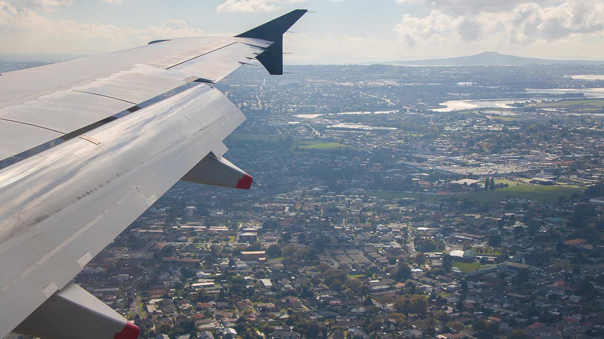Aerial view of Auckland from plane with wing in the frame.