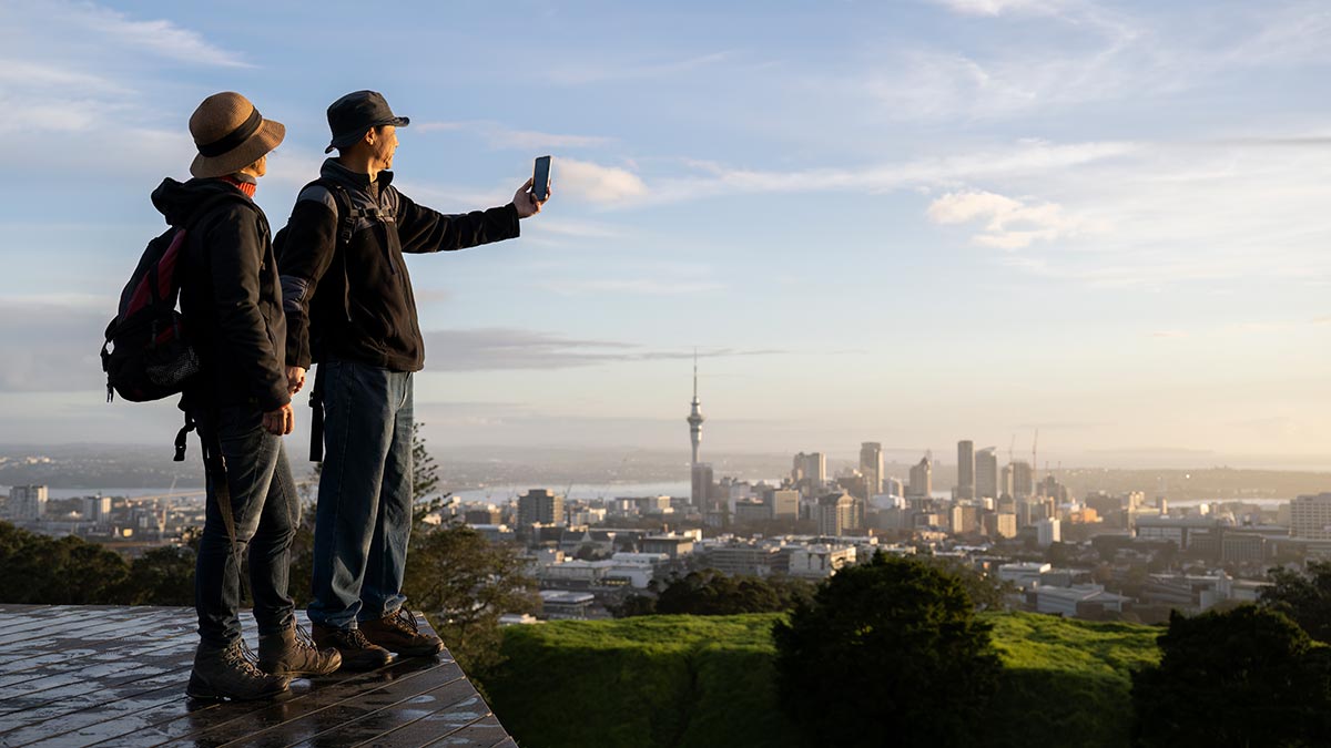 Couple taking photo from the top of Mount Eden in New Zealand