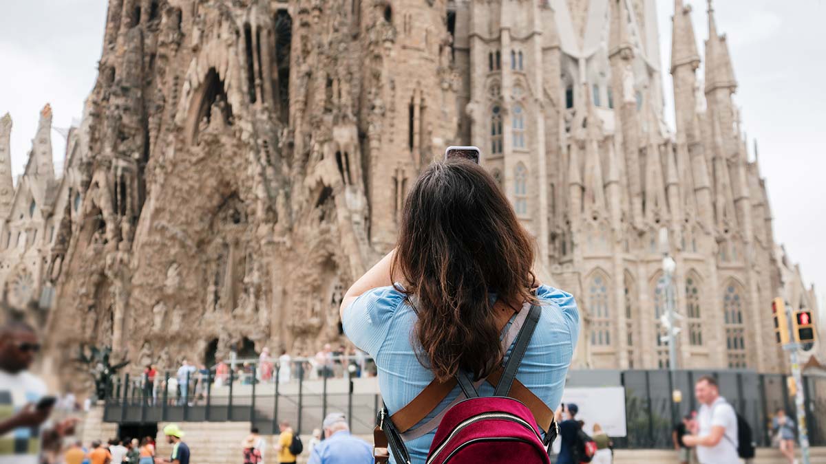 Female tourist taking photo of Sagrada Familia in Barcelona