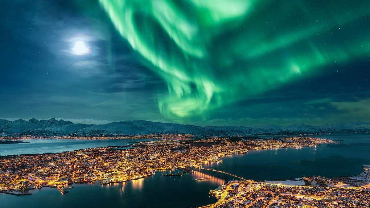 Northern Lights above lit up Tromso, Sweden