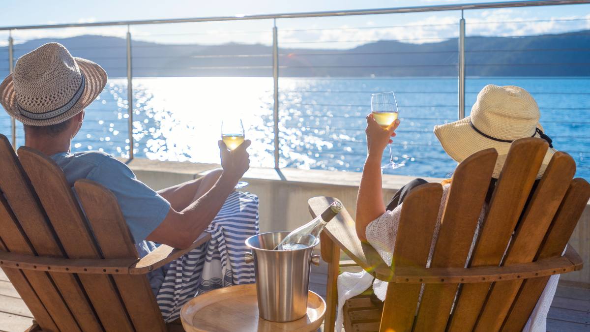 man and woman enjoying drinks on the deck of a cruise ship