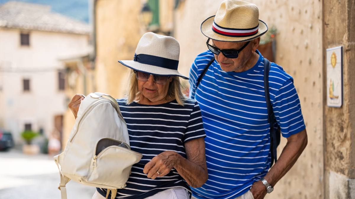 two seniors looking into open pocket of bag overseas