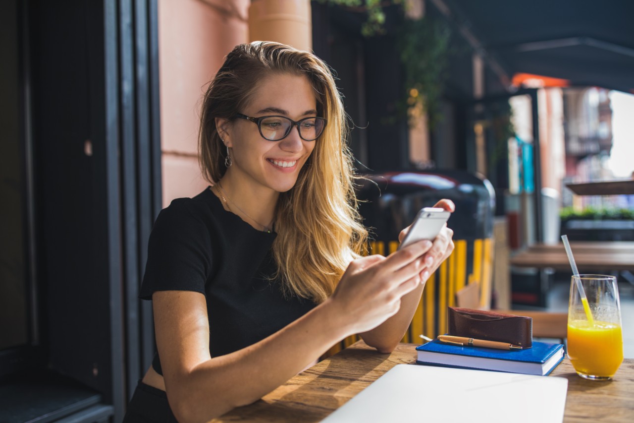 smiling woman on her smartphone in a cafe