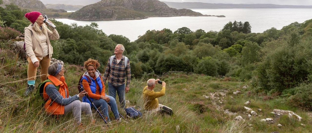 A group of middle-aged hikers stopping for lunch near Loch Torridon in northwest Scotland