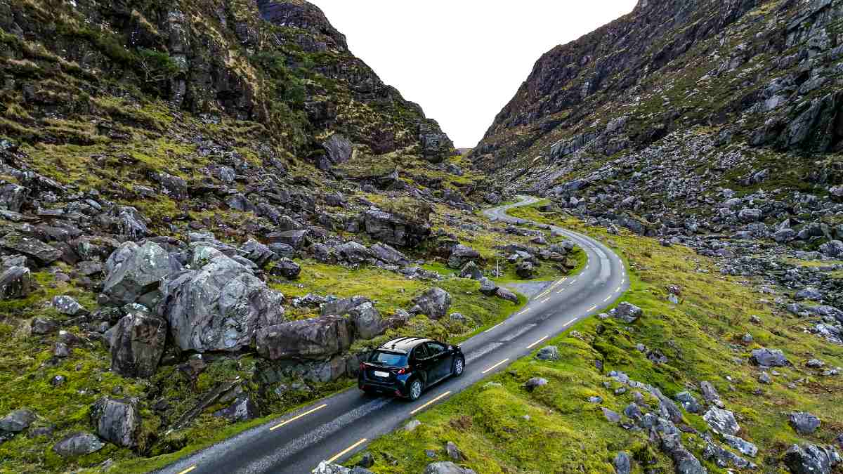 car driving on narrow country road in Ireland