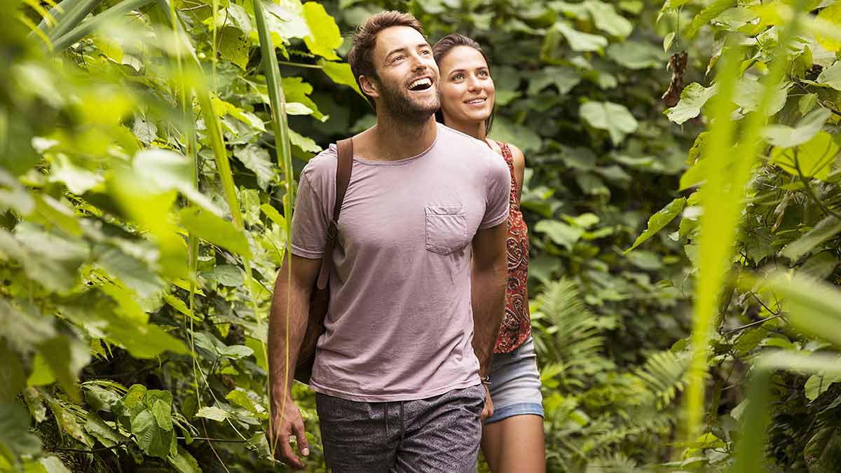 Young couple bushwalking in verdant forest in Fiji.