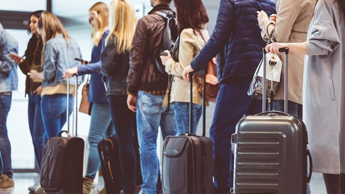 People lining up with bags to check in at airport