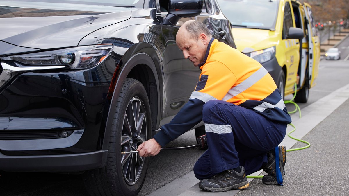 An RACV ERA driver fixing a flat tyre