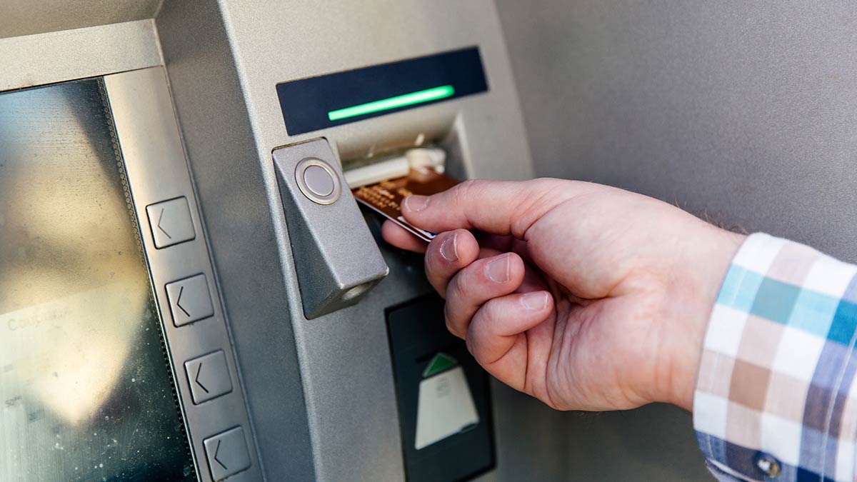 Hand putting card in ATM
