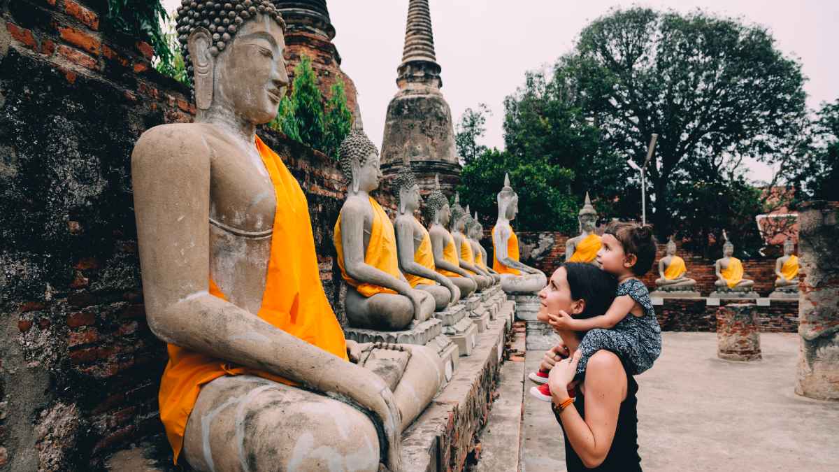 mother and daughter looking at Buddha statues in a temple