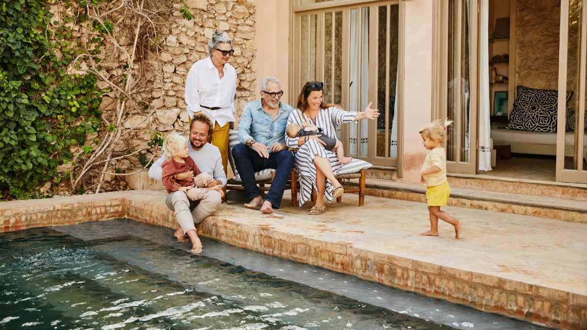 multi-generation family sitting around a pool at a holiday home