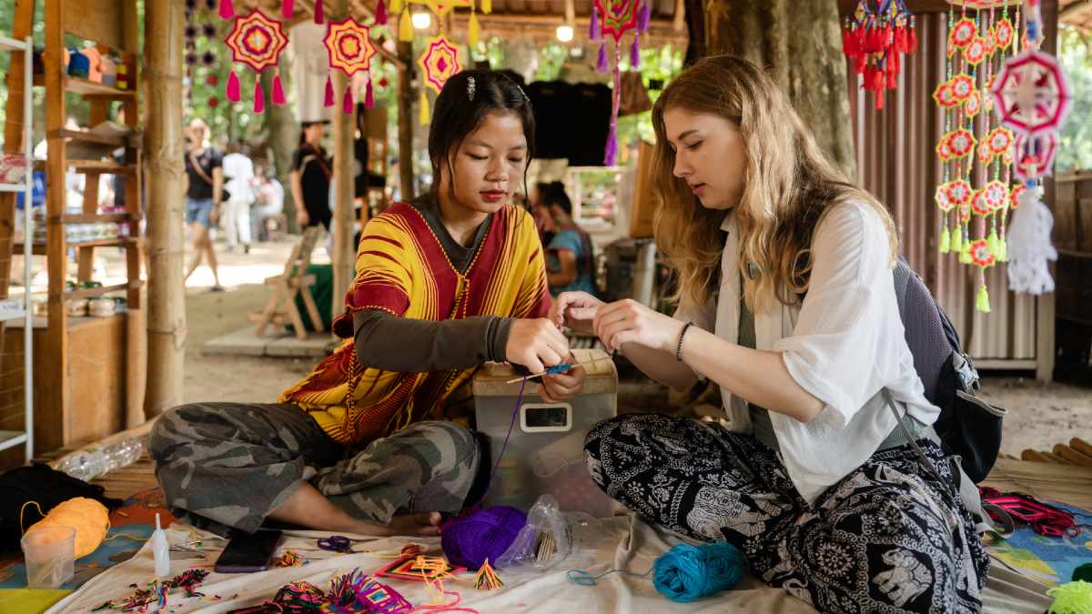 Thai woman teaching a tourist crafts