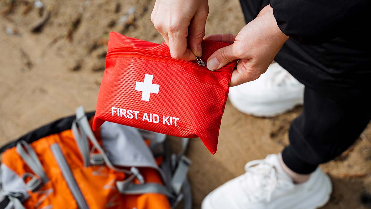 Woman opening first aid kit on beach