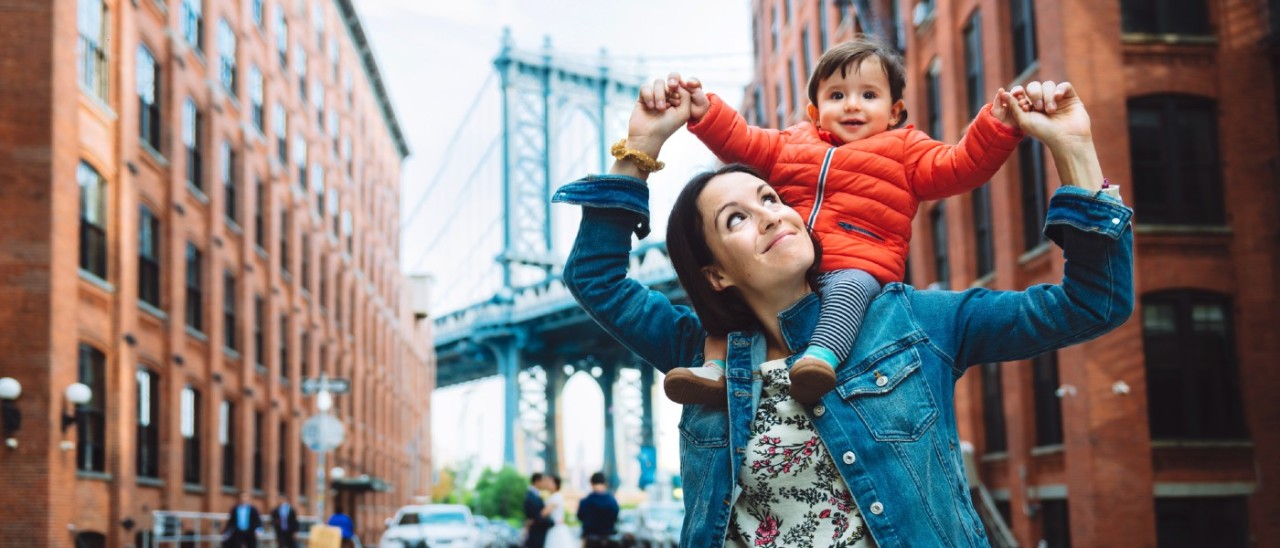 mother with young son on her shoulders smiling in New York City