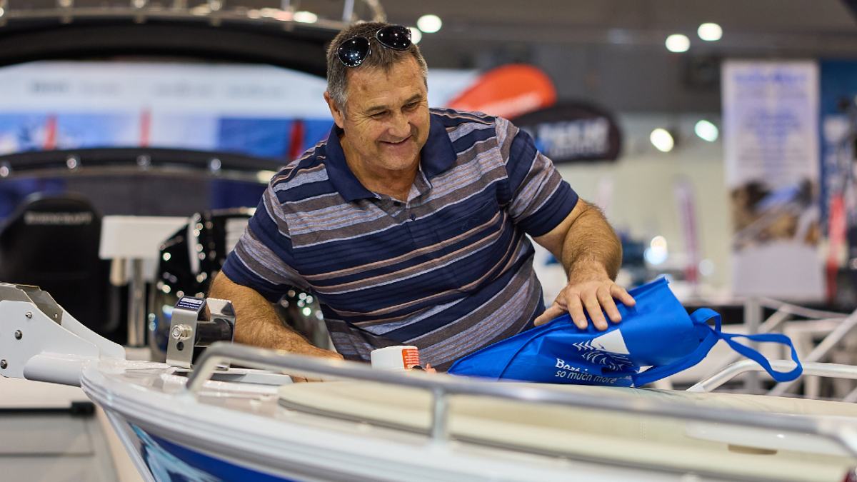 older man smiling while looking at a boat