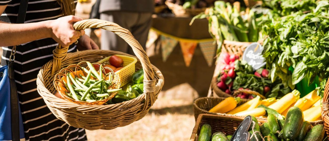 Warragul Farmers Market_Visit Victoria woman holding basket of vegetables at a farmers market