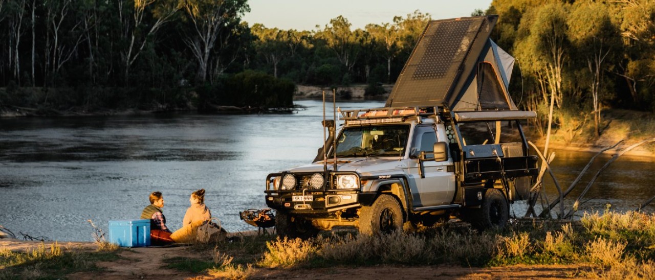 Two people camping by the Murray River with a pop-up FWD tent at the Forges Beach Campground 2