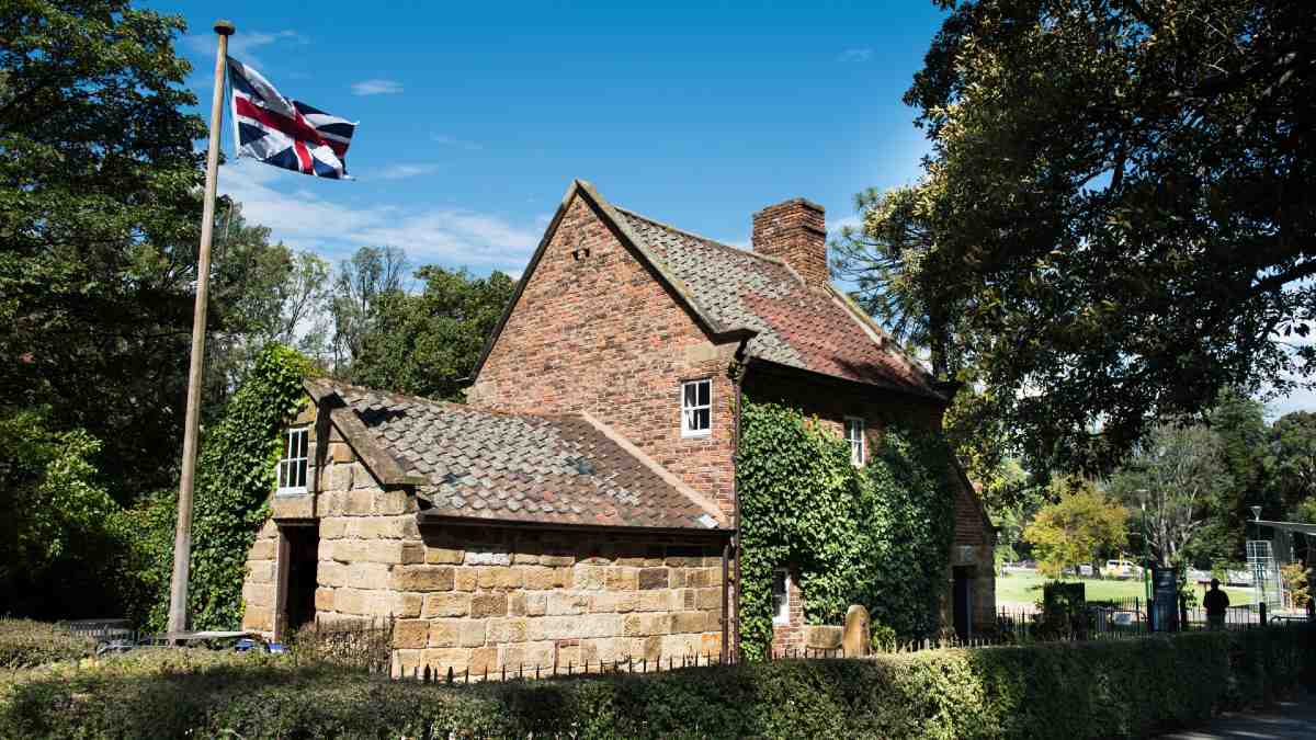 pretty brick cottage in gardens with Union Jack flag flying alongside