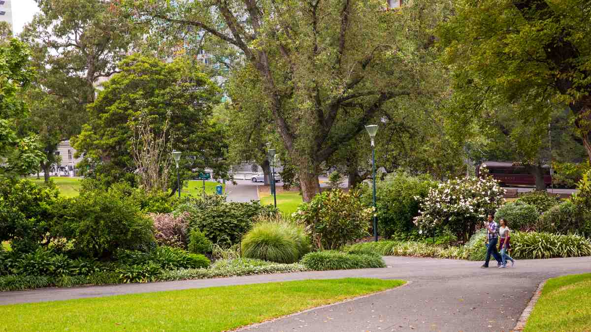 two people walking on paths through a lush garden