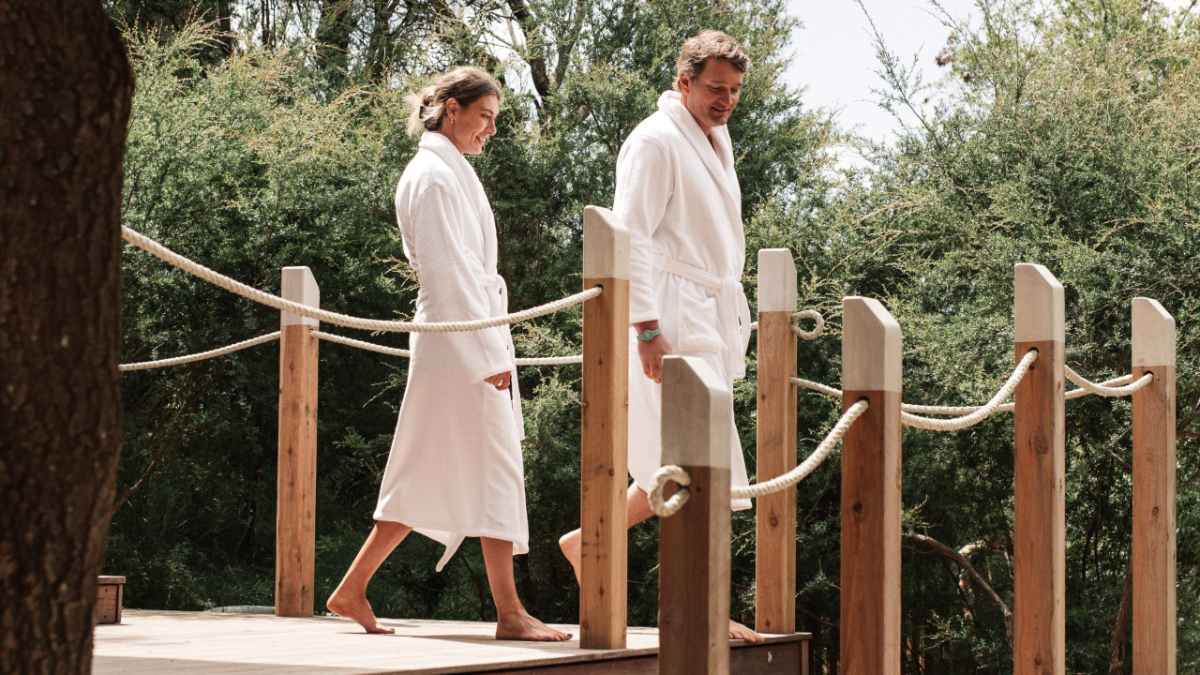 woman and man in bathrobes walking on boardwalk