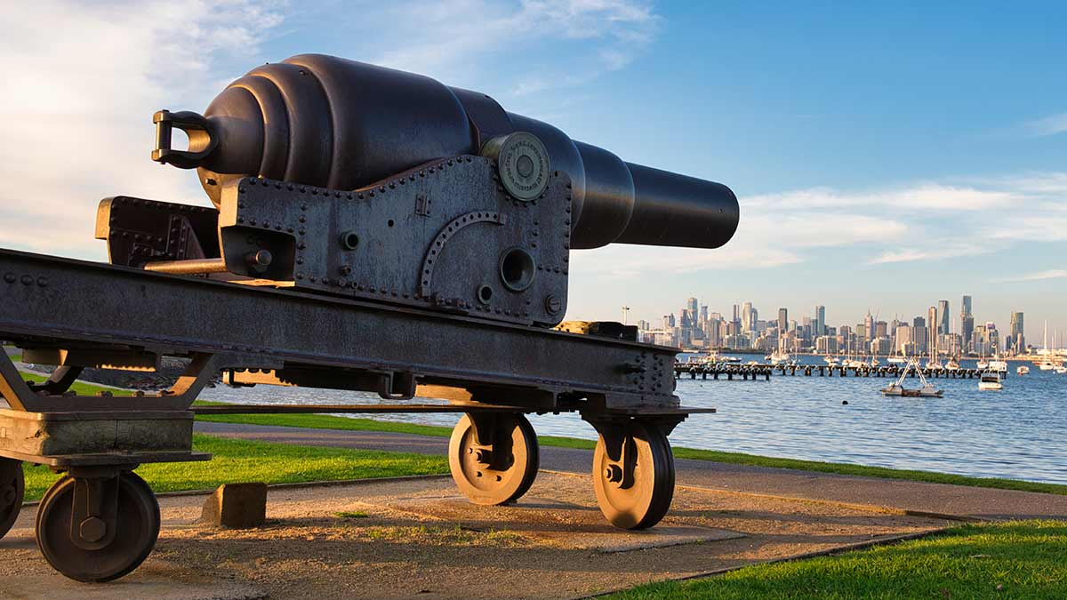 Historic Armstrong Cannon facing Port Phillip Bay at Williamstown with Melbourne city skyline behind