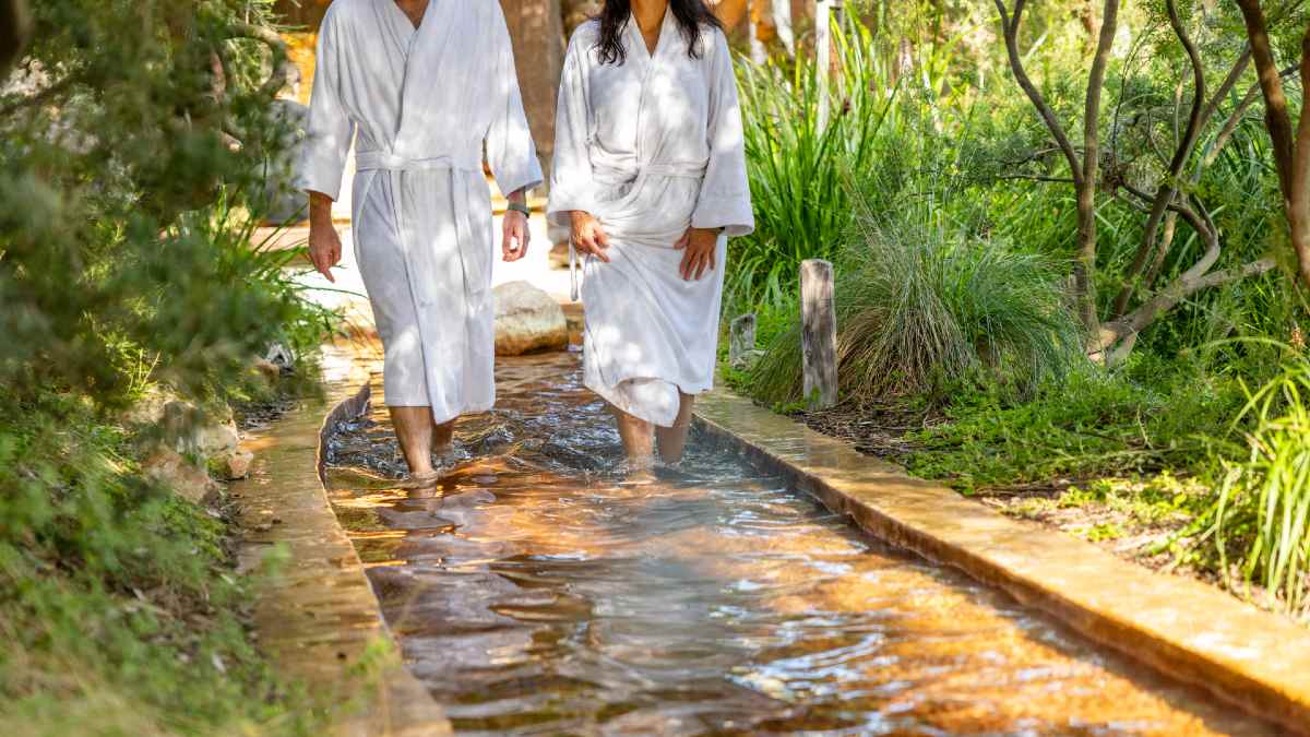 two people in bathrobes walking on a watery reflexology path