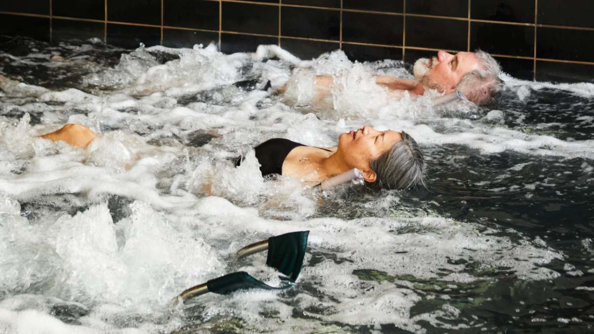 two older people relaxing in bubbling hot springs